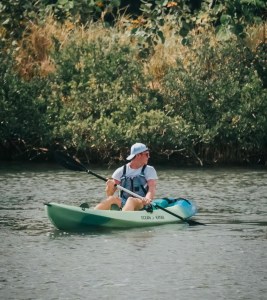 a man riding on the back of a boat in the water